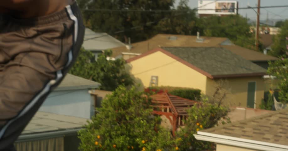 A man stretches on the roof shirtless