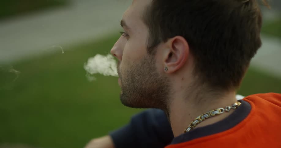 A man smokes a cigarette outside
