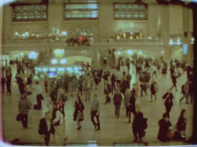 Commuters walk through a busy station