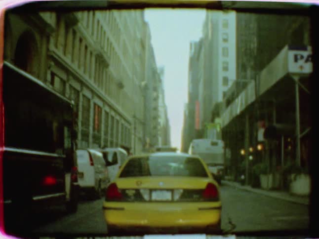 A taxi travels down a city street