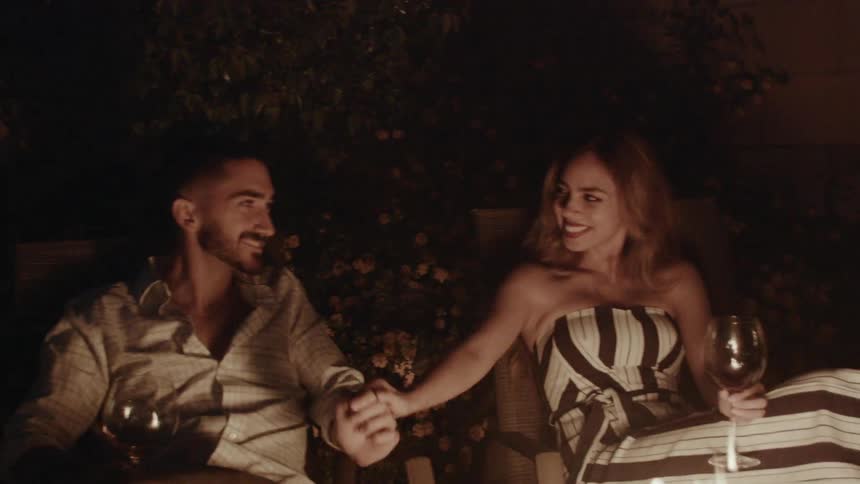 The man kisses a woman's hand by the fire
