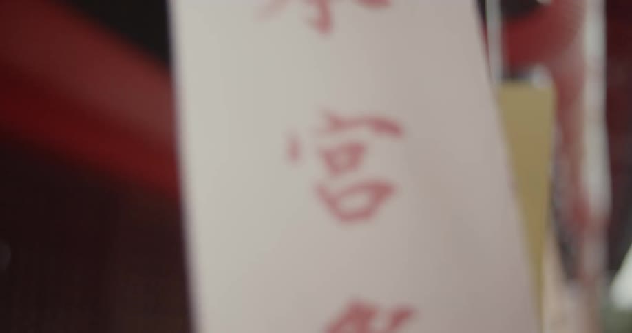 Tags with asian characters hang from string and wave in the wind