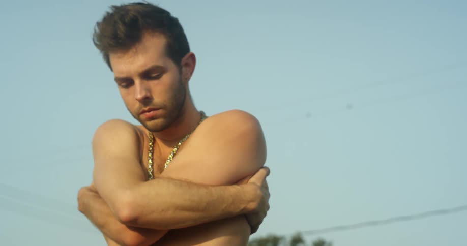 A man crosses his arm outside