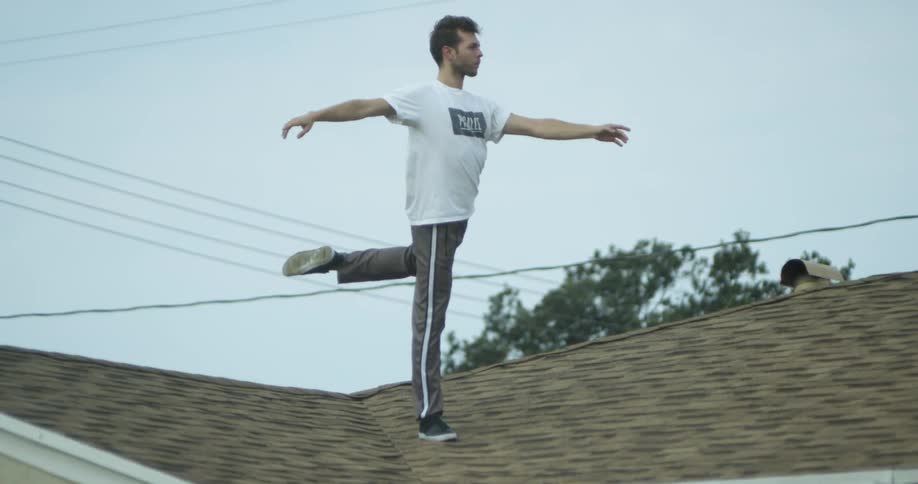 The man is doing yoga on the roof