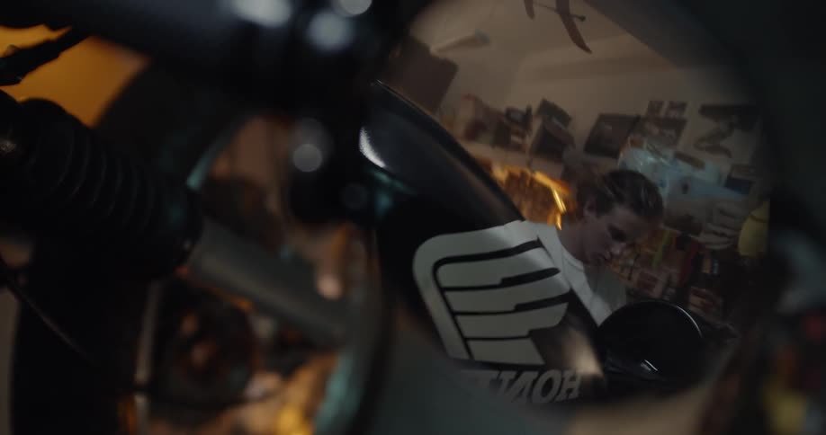 A man works on a motorcycle in a garage