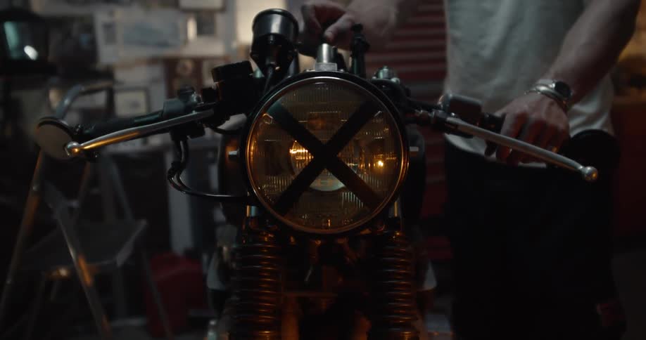 A man turns on the headlamp of a motorcycle