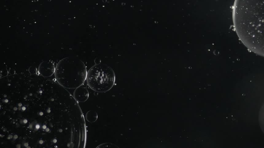 The bubbles slowly move in the dark liquid
