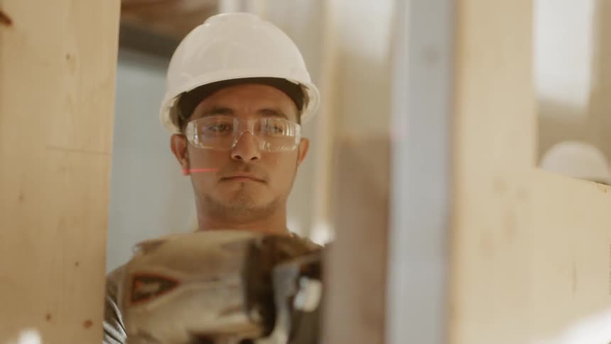 Man in hardhat drills into board