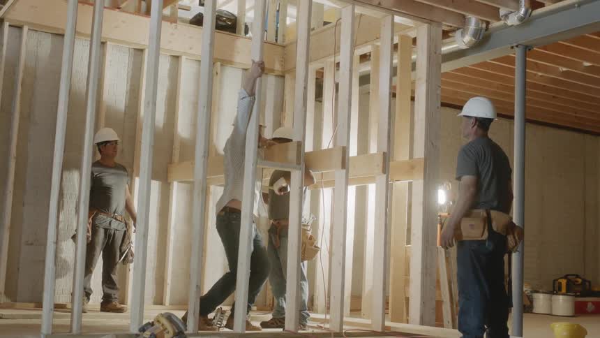 A construction worker climbs up to the second floor