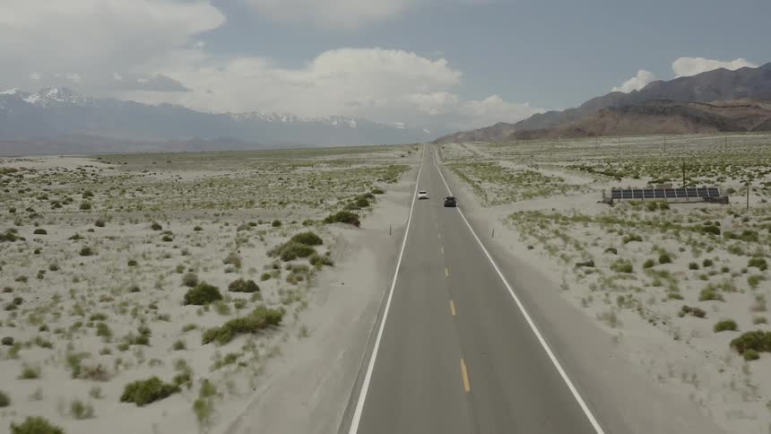 Cars drive on a rural desert road
