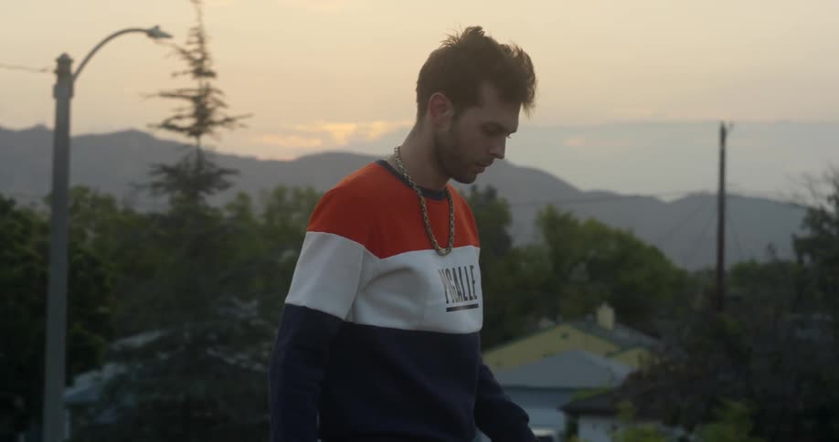 A man walks outside at sunset