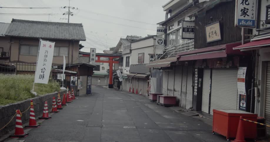 Banners with asian characters stand near closed shops on a road