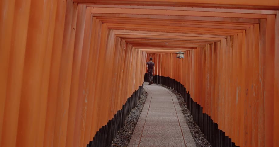 A man walks under a line of arches