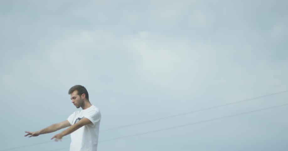 Man is dancing outside on cloudy day