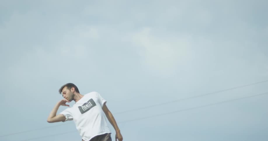 A man is dancing outside on a cloudy day