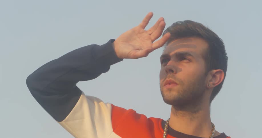 A man shields his face from sunlight