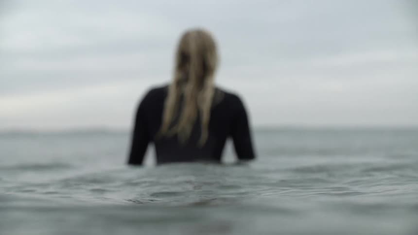 The woman is wading through the water