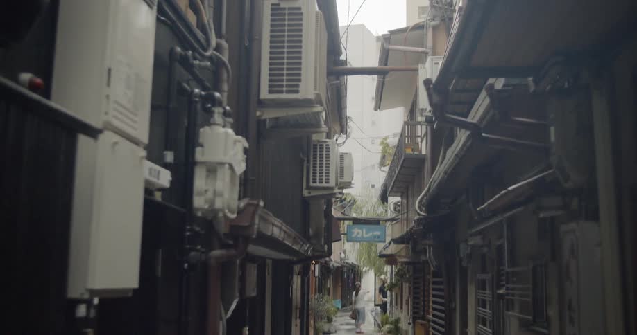 A woman walks in a narrow alley