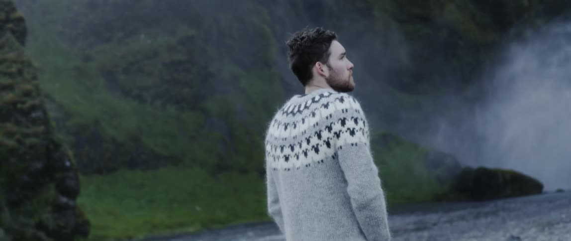 Man is walking near waterfall in wilderness