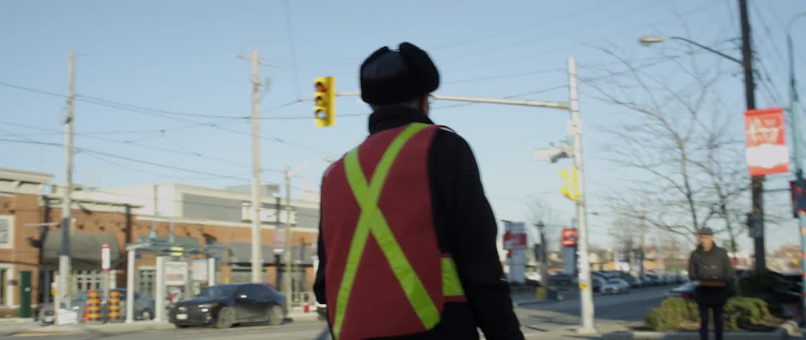 A crossing guard walks to the corner