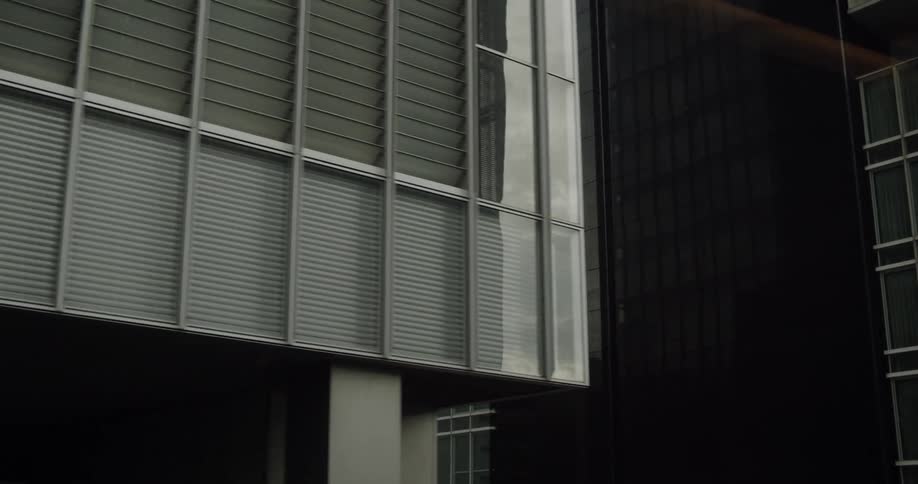Buildings with many windows sit under a cloudy sky