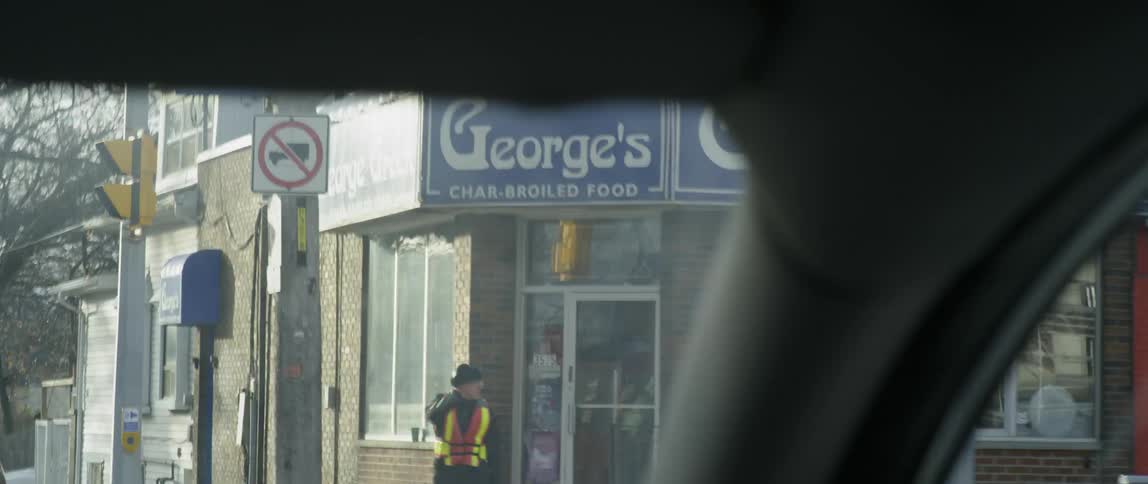 A crossing guard stretches his arms on the corner