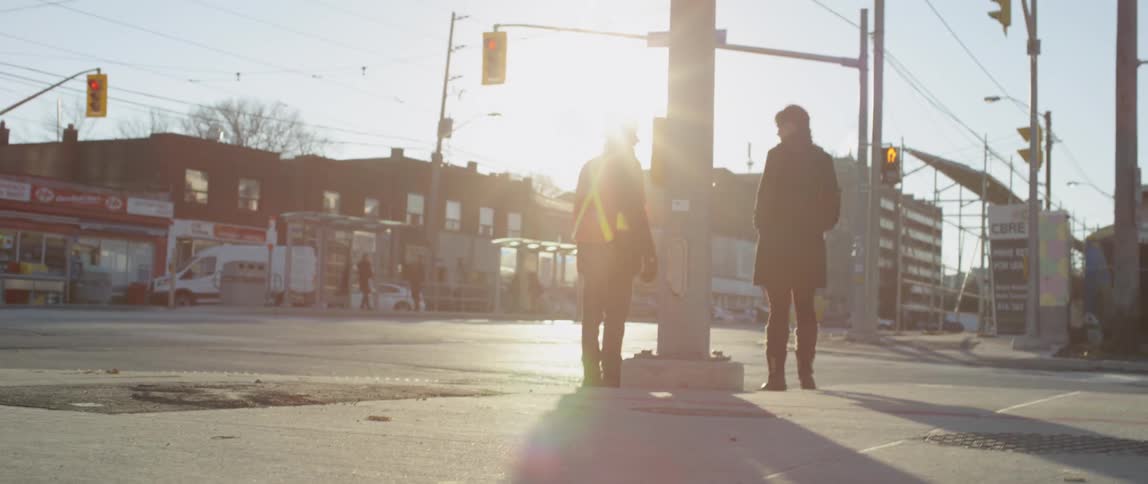 Two people stand on the street corner