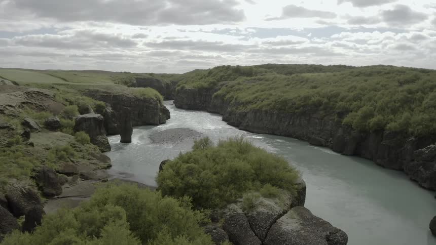 River flowing through rock canyon wilderness on cloudy day
