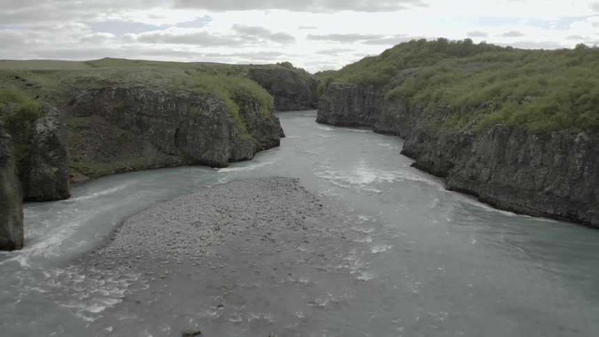 River flowing through rock canyon wilderness on cloudy day