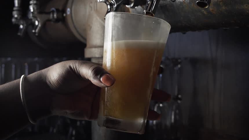 A woman fills a beer glass from a tap