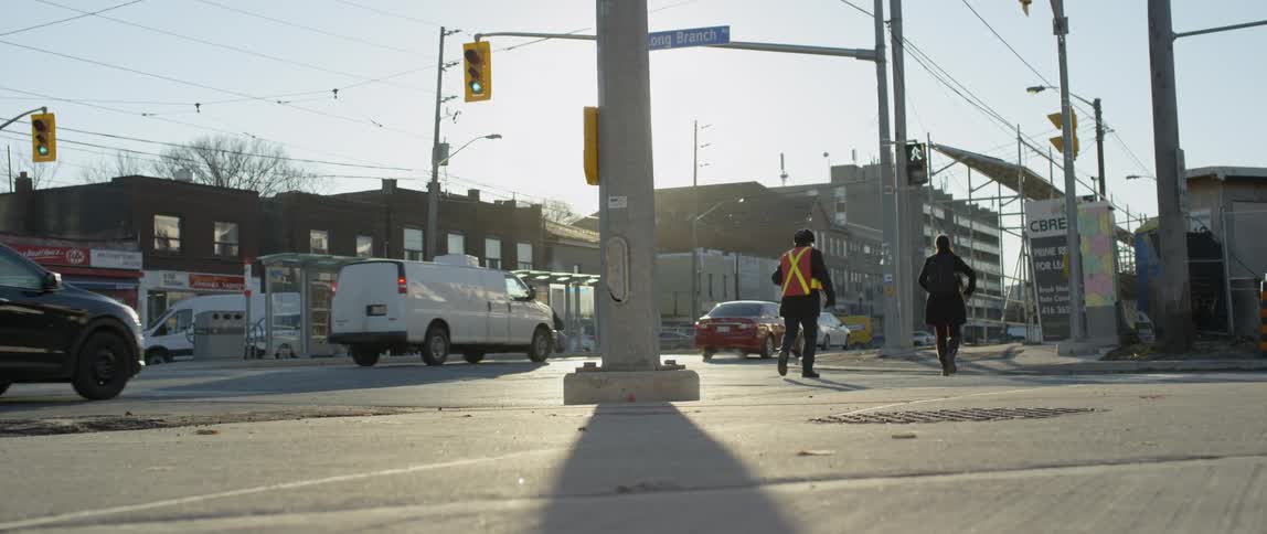 A crossing guard marches across the street