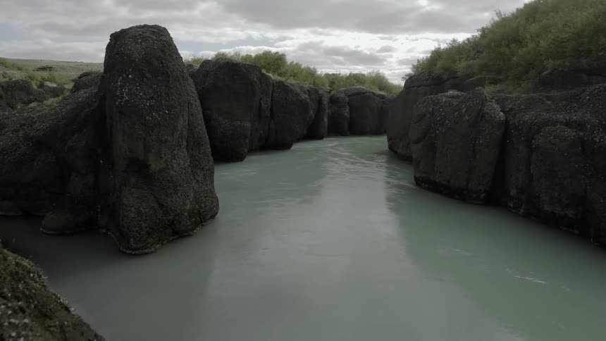 A river is flowing through a ravine in daylight