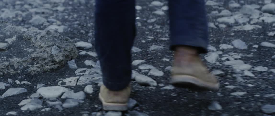 Person walking across rocky ground