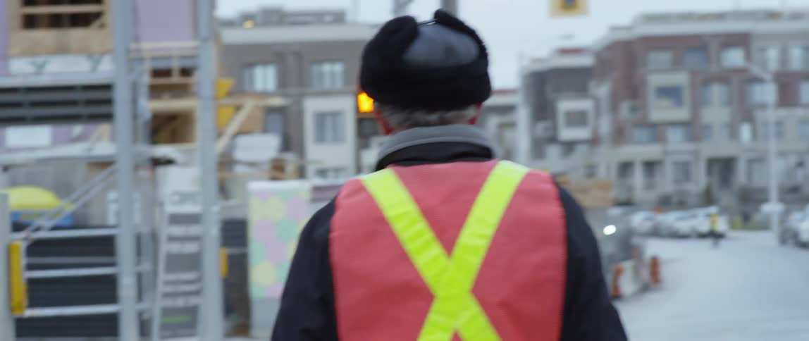 Man wearing a vest holds a stop sign