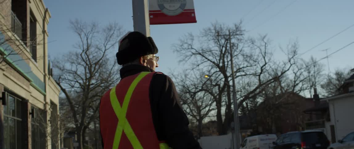 A man is holding a stop sign on the corner