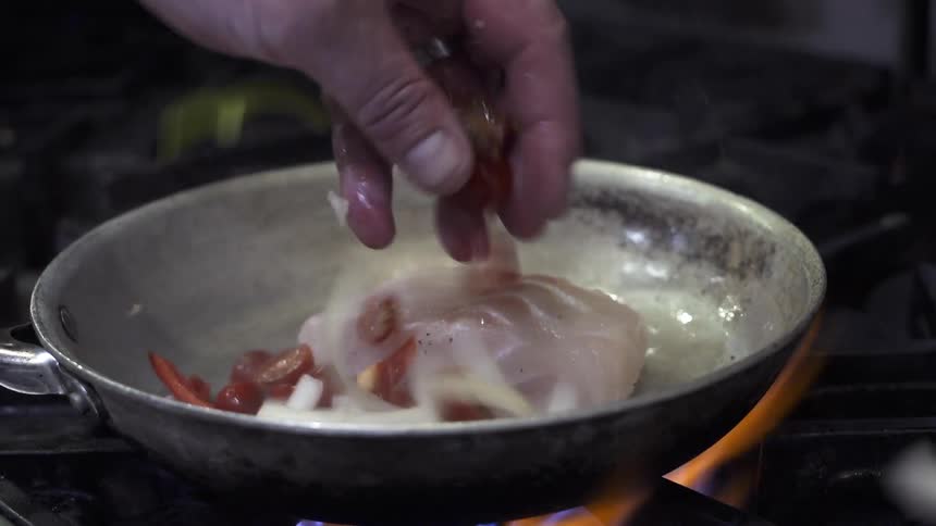 Fish and vegetables are seared in a pan