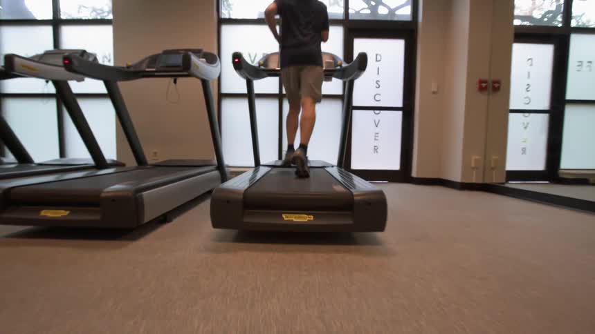 Man jogs on a treadmill in the gym