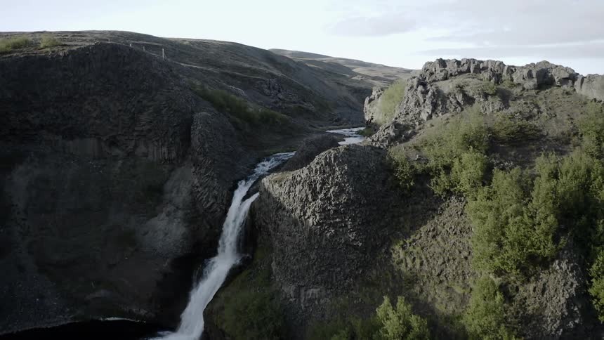 A waterfall flows over a cliff in the wilderness