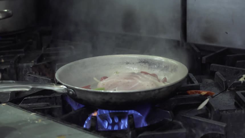 Fish and vegetables are seared in a pan