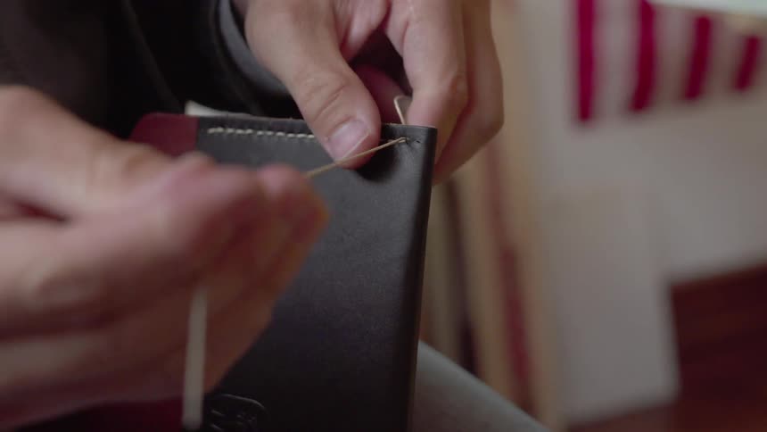 A man stitches leather