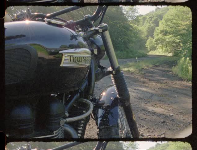 A motorcycle is parked on the side of a rural road