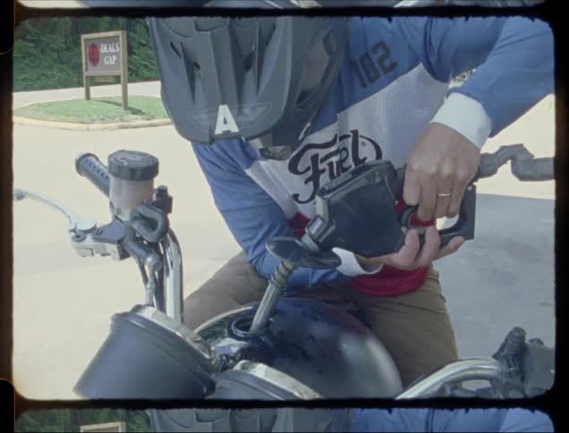 A man fills the tank on his motorcycle