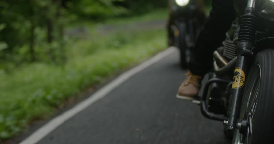 Motorcyclists ride on a rural road