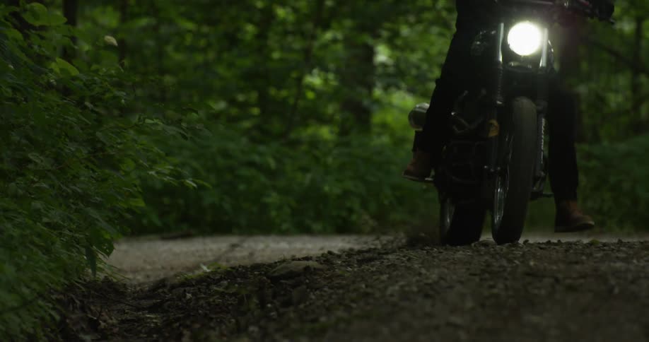 A man rides a dirt bike through the woods