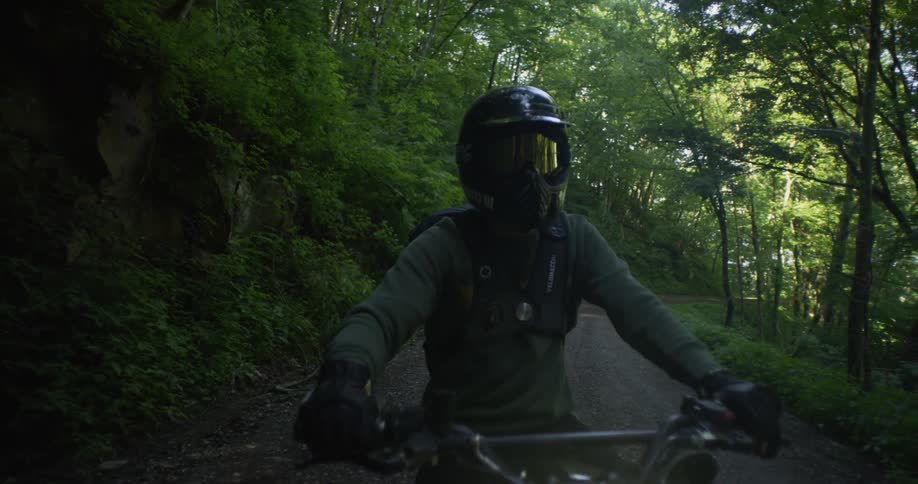 A motorcyclist rides in a forest