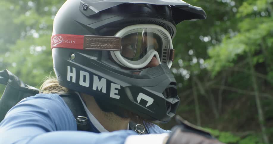 A man sits on a motorcycle with a helmet on