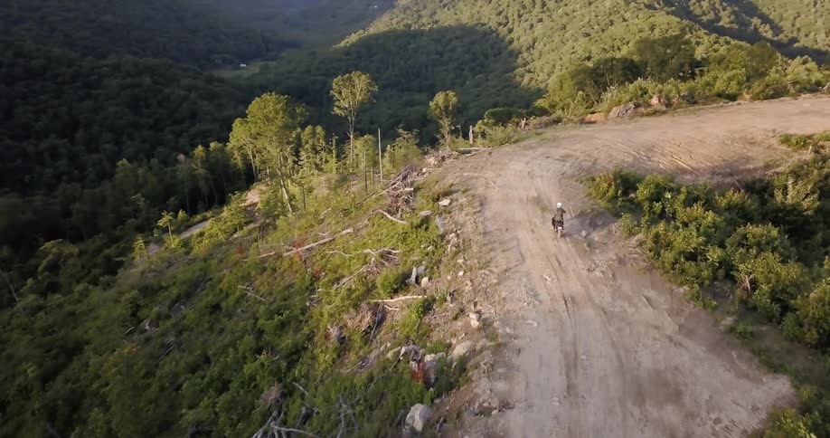 A man rides a motorcycle on a dirt path