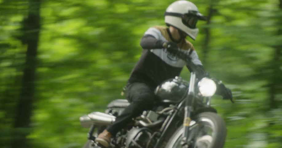 Person rides a motorbike through the woods