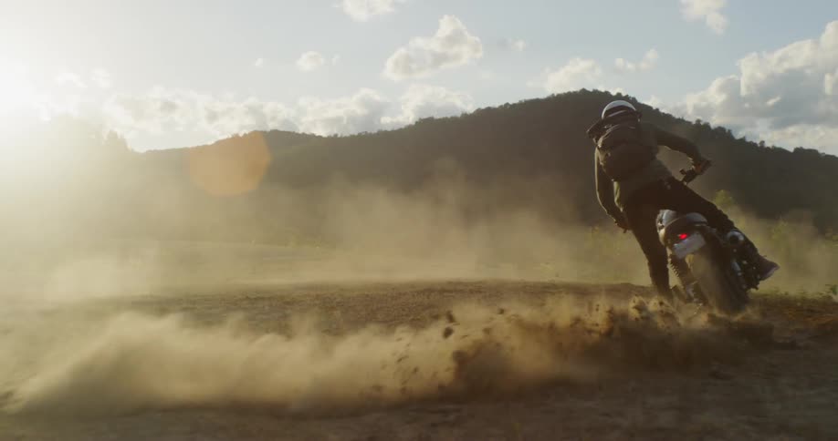 A man skids out on a dirt bike