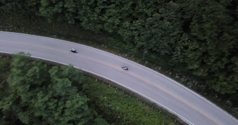Two motorcycles ride on the winding road